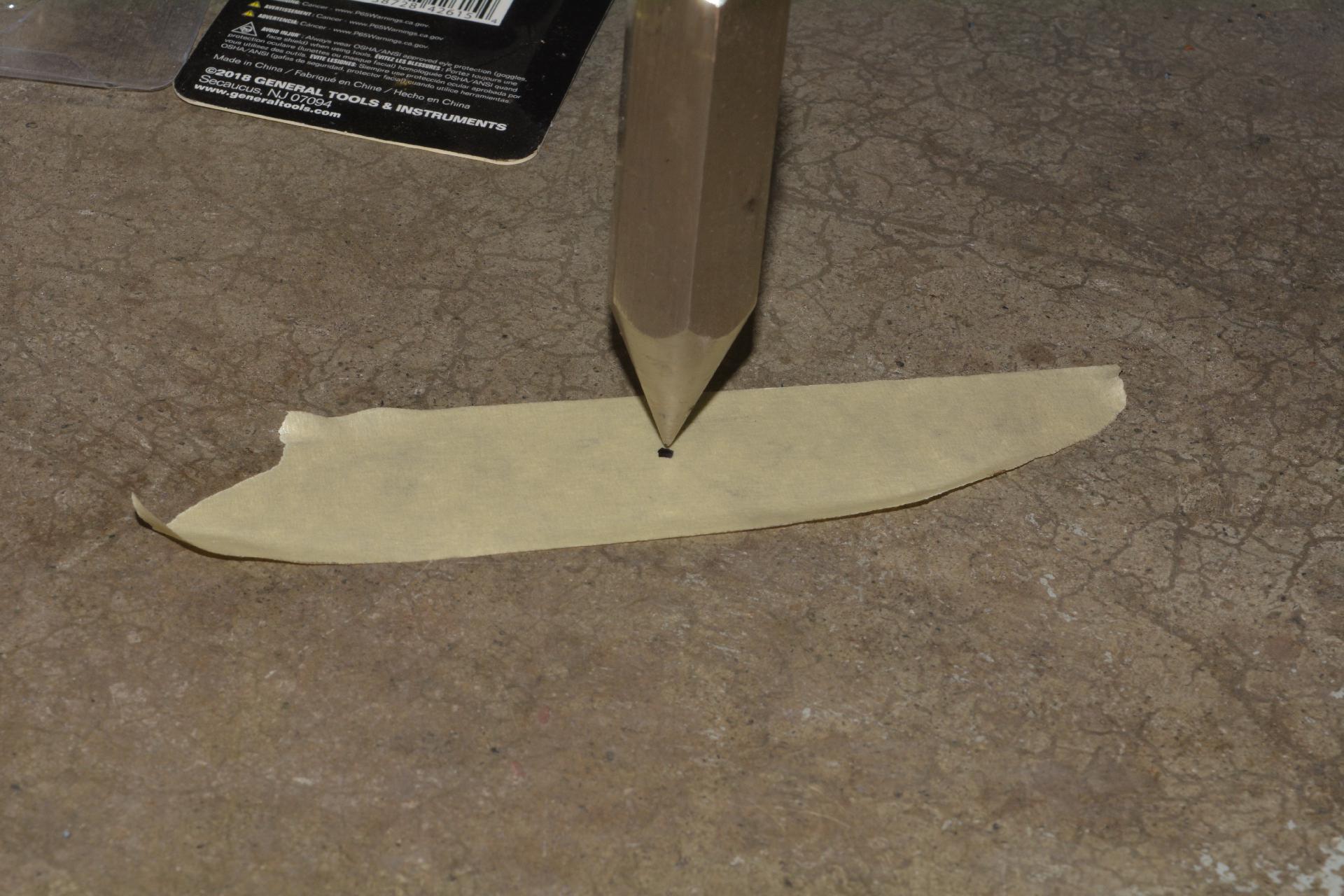 Make a dot on some tape directly under the point